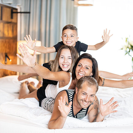 Familie liegt im Bett im Thermenhotel Vier Jahreszeiten