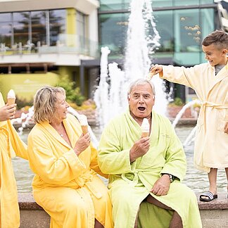 Familie isst Eis am Springbrunnen beim Thermenhotel Vier Jahreszeiten