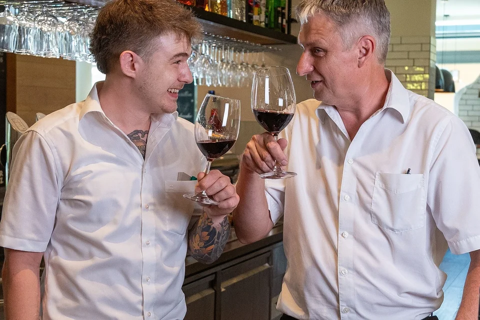 Kellner mit einem Glas Rotwein im Restaurant Zum Horst