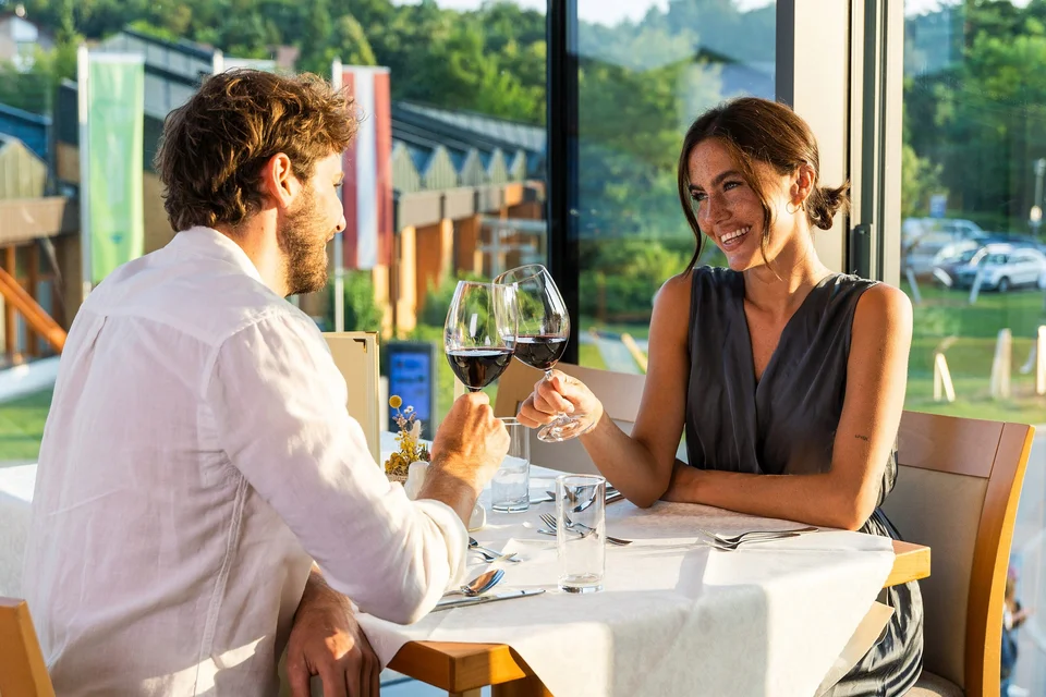 Paar trinkt einen Rotwein auf der Terrasse im Thermenhotel Vier Jahreszeiten