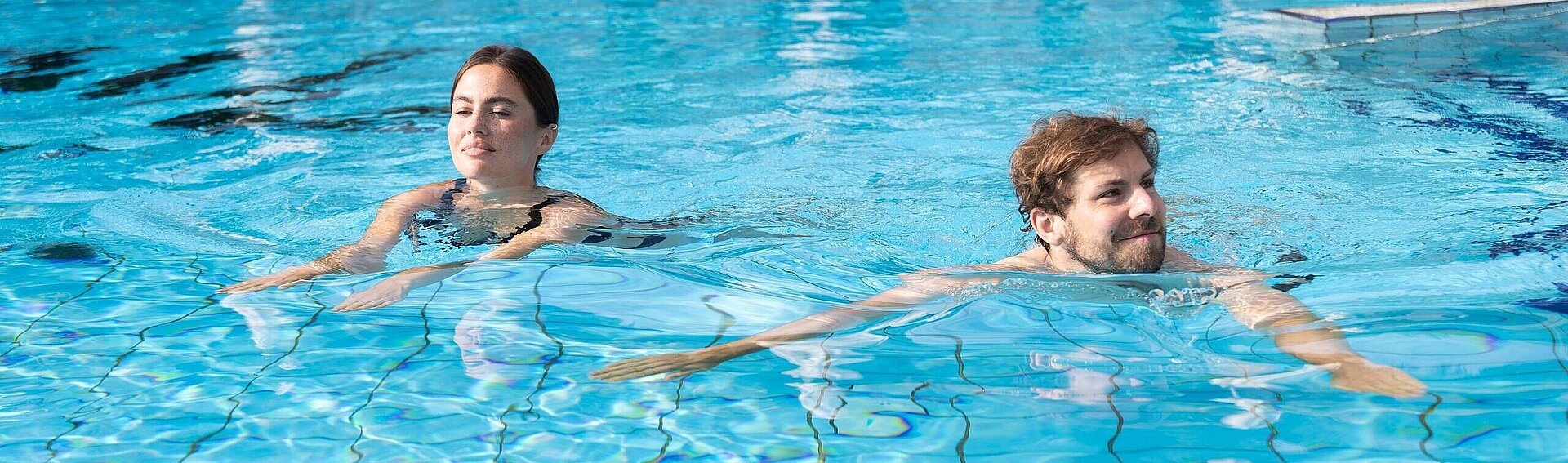 Pärchen schwimmt im Pool vom Thermenhotel Vier Jahreszeiten