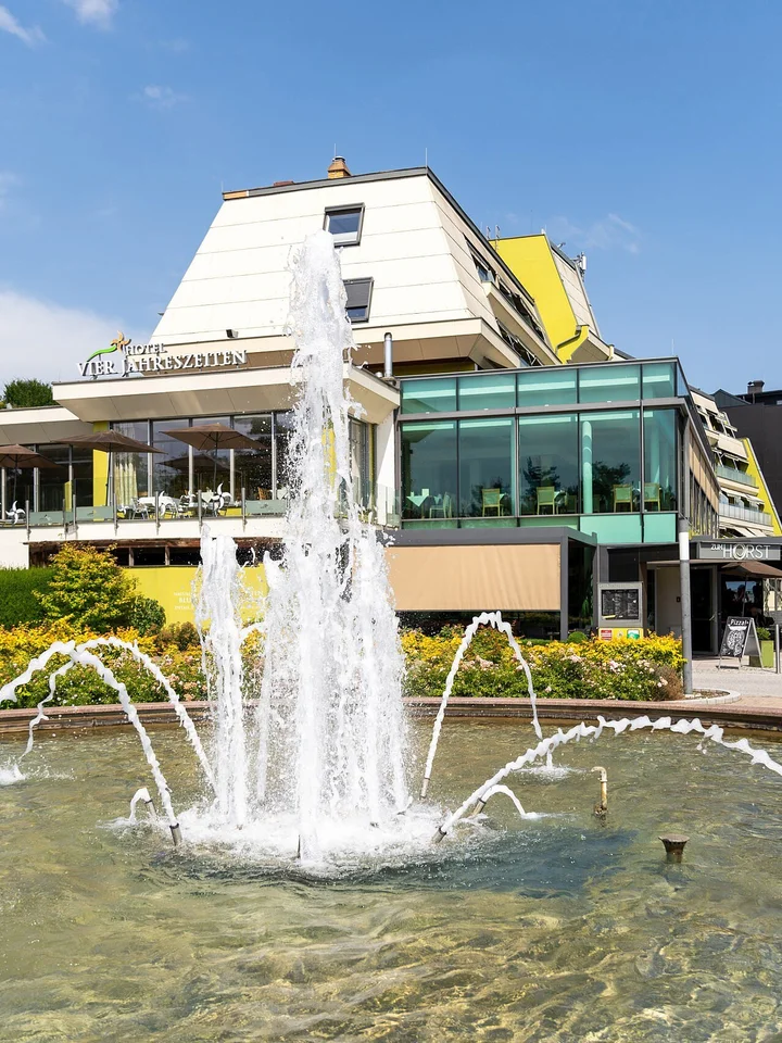 Springbrunnen bei blauem Himmel vor dem Thermenhotel Vier Jahreszeiten